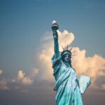 Iconic Statue of Liberty with majestic clouds in New York, USA. Perfect travel destination image.